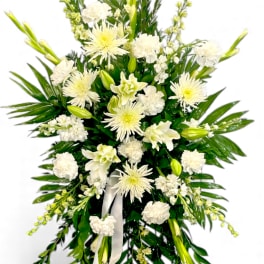 White floral standing spray on an easel with ribbon
