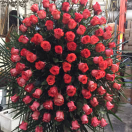 Large standing spray of red roses with palm fronds