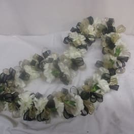 White floral lei with black and gold ribbon loops