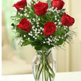 Bouquet of red roses and baby's breath in a clear glass vase