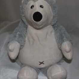 Gray and white plush teddy bear with a stitched mouth and open black nose