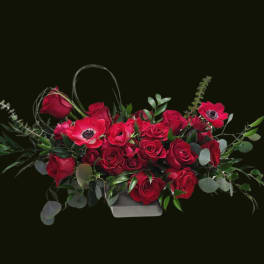 Red roses and red anemones in a low rectangular container
