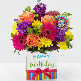 Bright mixed bouquet in a birthday gift box with a ribbon