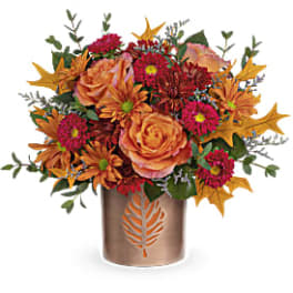 Autumn bouquet of orange roses and magenta mums in a bronze vase