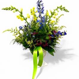 Tall mixed flower arrangement with blue, yellow, and burgundy blooms in a vase