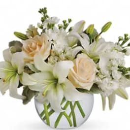 White lilies and pale roses arranged in a round vase