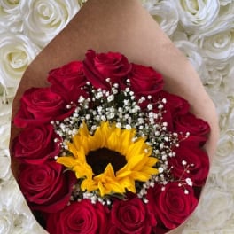 Bouquet of red roses with a sunflower and baby's breath in brown paper