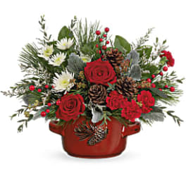Red roses and white flowers in a red ceramic pot with pinecones