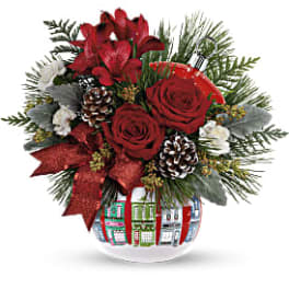 Red roses and lilies in a decorated glass vase with pinecones