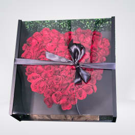 Heart-shaped box of red roses tied with a black ribbon