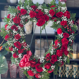 Heart-shaped floral wreath with red roses and carnations