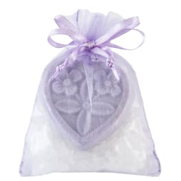 Lavender organza gift bag with a heart-shaped decorative piece and white crystals inside.