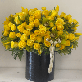 Yellow roses and tulips arranged in a black vase