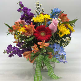 Colorful mixed bouquet in a clear glass vase with a green gingham ribbon