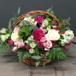 Basket of pink and white roses with greenery