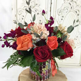 Mixed bouquet of roses and carnations in a mosaic vase