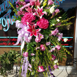 Tall standing floral spray with pink and white blooms on an easel