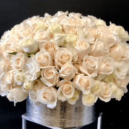 Cream roses arranged in a silver vase