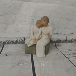 Small figurine of two seated people in white clothing