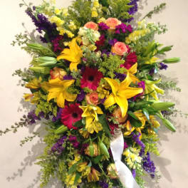 Large standing spray with yellow lilies, pink roses, and purple flowers