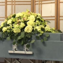 Large yellow floral arrangement on top of a casket