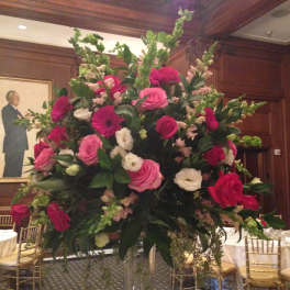 Large pink and white floral centerpiece in a clear vase