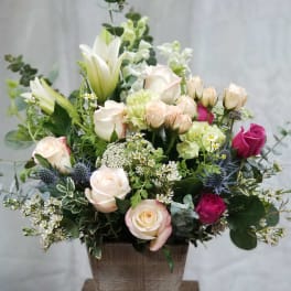 Mixed rose and lily arrangement in a square vase