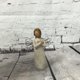 Small angel figurine with wire wings on a wooden surface