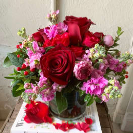 Bouquet of red roses and pink flowers in a glass vase