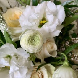 Close-up bouquet of white and cream flowers with green accents
