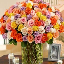 Large bouquet of multicolored roses in a clear glass vase