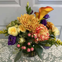 Mixed bouquet with orange calla lilies, chrysanthemums, roses, and pink berries