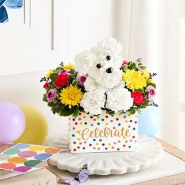Colorful flower arrangement in a polka-dot box with a teddy bear centerpiece