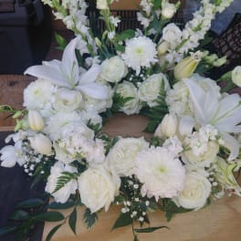 White floral wreath with roses, lilies, and chrysanthemums