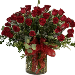 Bouquet of red roses in a clear glass vase with a red ribbon