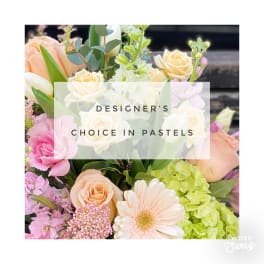 Pastel arrangement of roses, gerbera daisy, tulips, and hydrangea with text reading Designer's Choice in Pastels