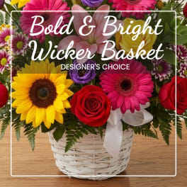 Colorful mixed flower basket in a white wicker basket with ribbon