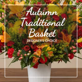 Autumn flower basket in a white container with red, orange, and yellow blooms