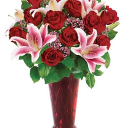 Red roses and pink lilies arranged in a tall red vase