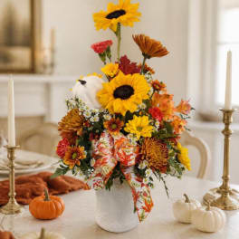 Autumn floral arrangement with sunflowers and chrysanthemums in a white vase