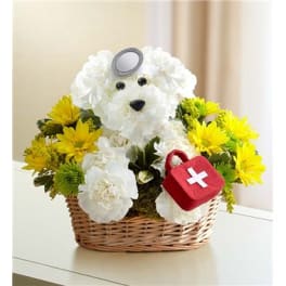 White teddy bear floral arrangement in a wicker basket with yellow and white flowers