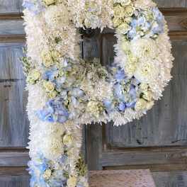 Large floral letter P made of white and pale blue flowers