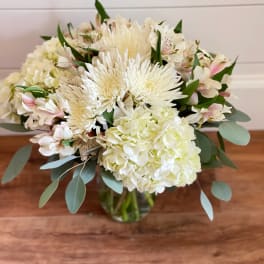 White bouquet with hydrangea, chrysanthemums, and pale pink alstroemeria in a glass vase