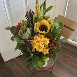 Mixed bouquet with a sunflower, yellow mums, lilies, and a succulent