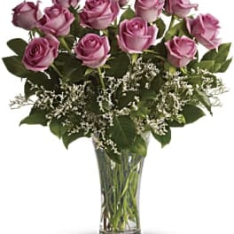 Lavender roses arranged in a clear glass vase