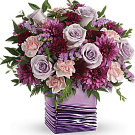 Lavender roses and purple flowers in a purple vase