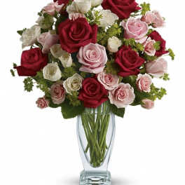 Bouquet of red, pink, and white roses in a clear glass vase