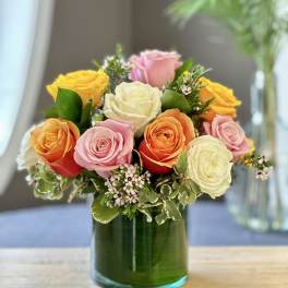 Mixed roses arranged in a green glass vase