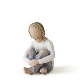 Wooden figurine of a seated child hugging their knees