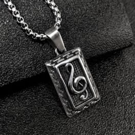 Silver music note pendant necklace on black fabric